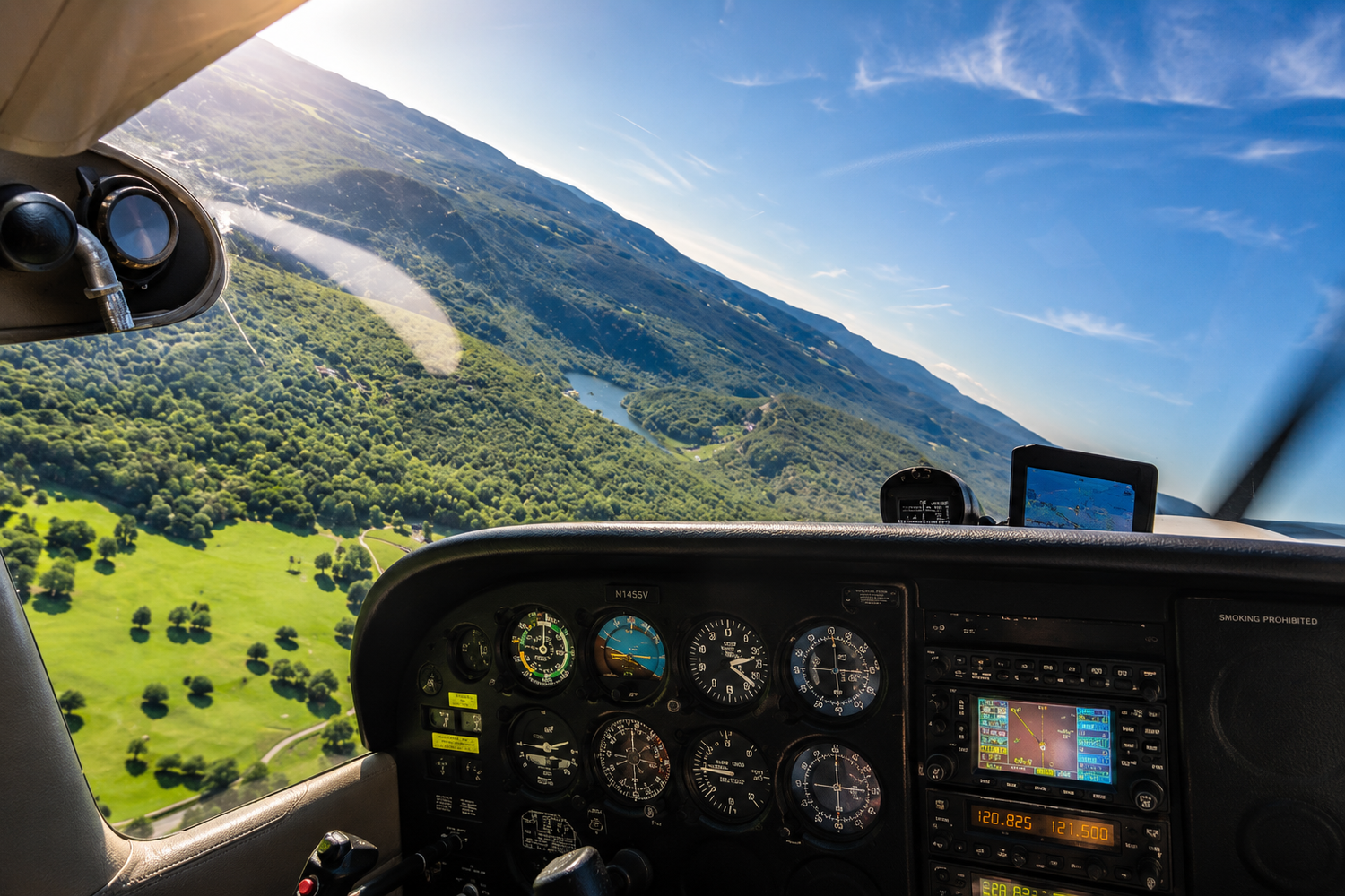 View from inside a Cessna 172 cockpit during flight, overlooking rolling hills, forests, and a winding lake below, capturing the freedom and excitement of learning to fly.